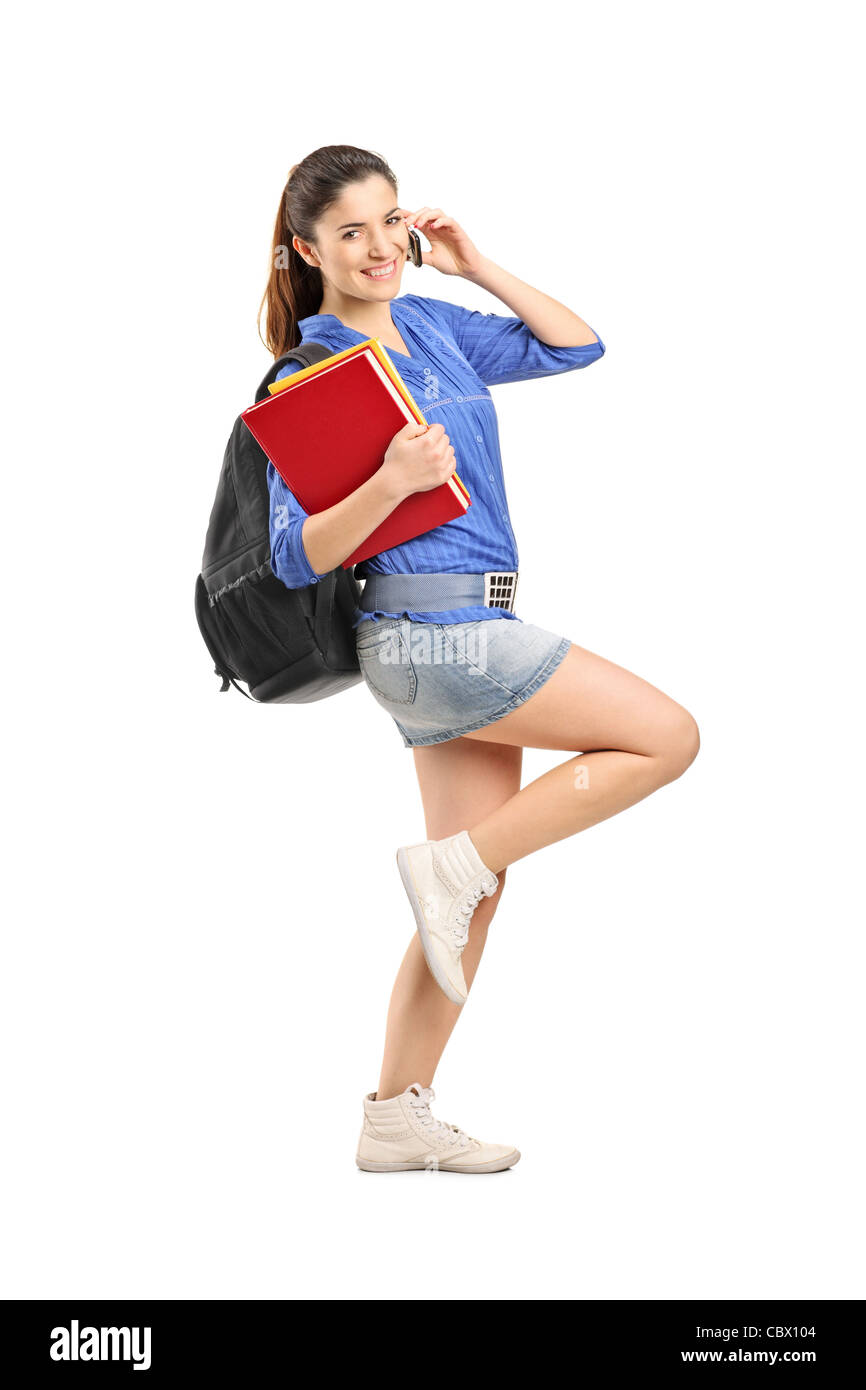 Full length portrait of a smiling school girl holding books and talking ...