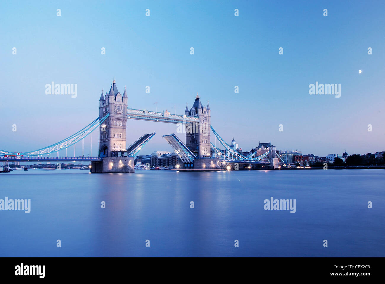 Tower Bridge at dusk, with the two towers lit up and Thames water looking blue. Stock Photo
