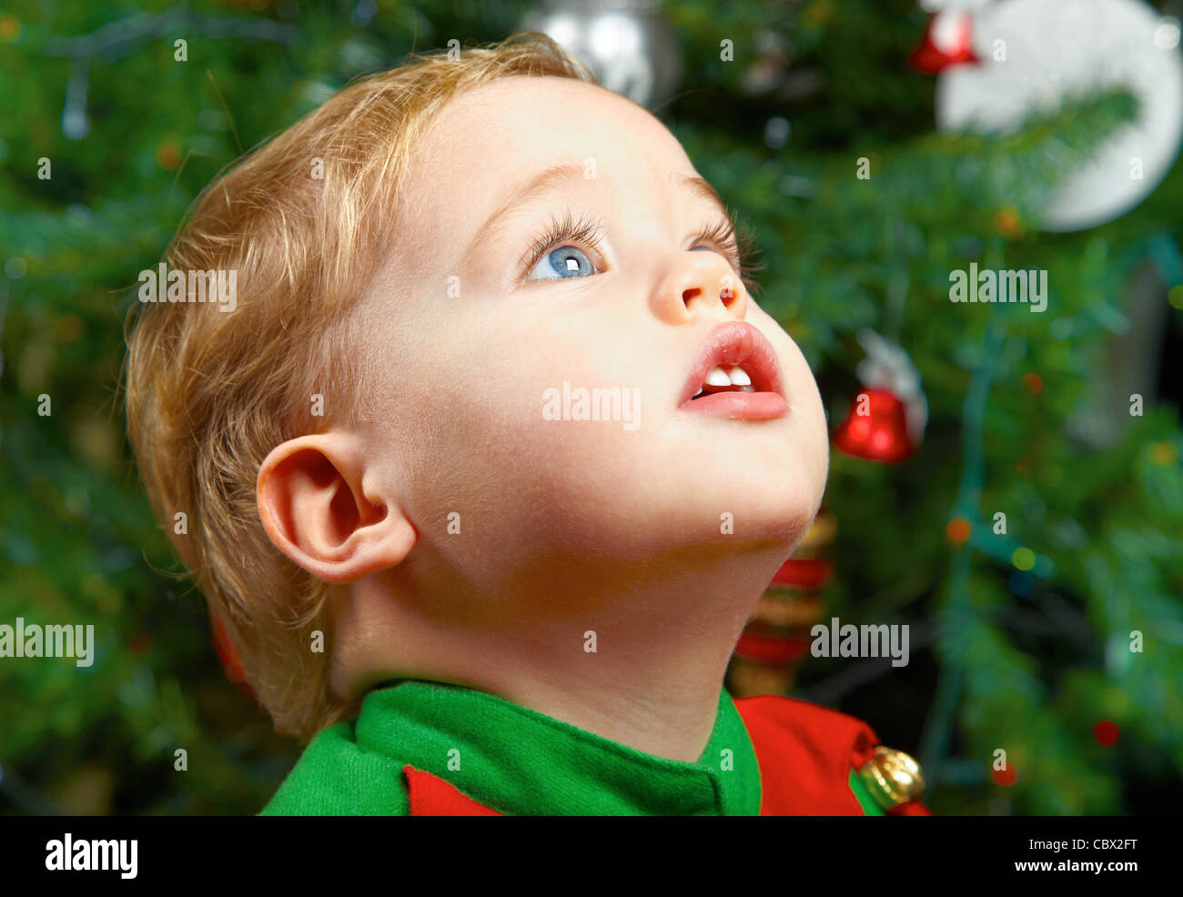 Cute 1 year old baby boy at the Christmas tree. Stock Photo