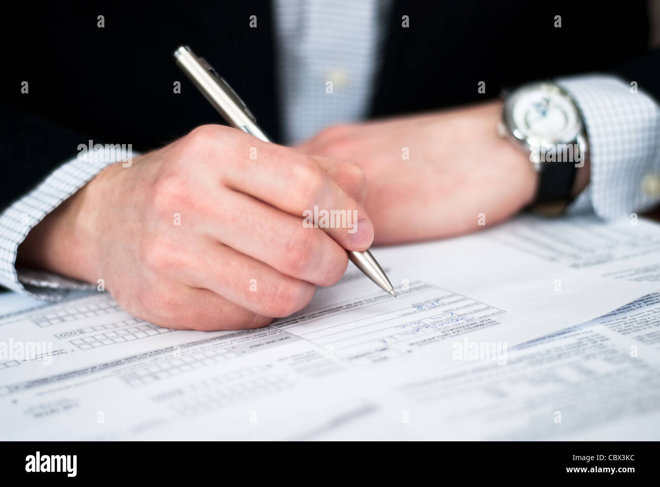 Filling out business documents on a desk Stock Photo
