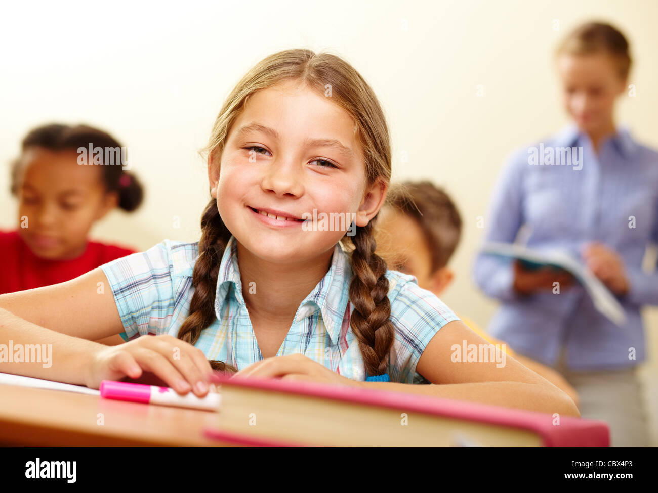 Portrait of lovely girl looking at camera with smile in classroom Stock ...