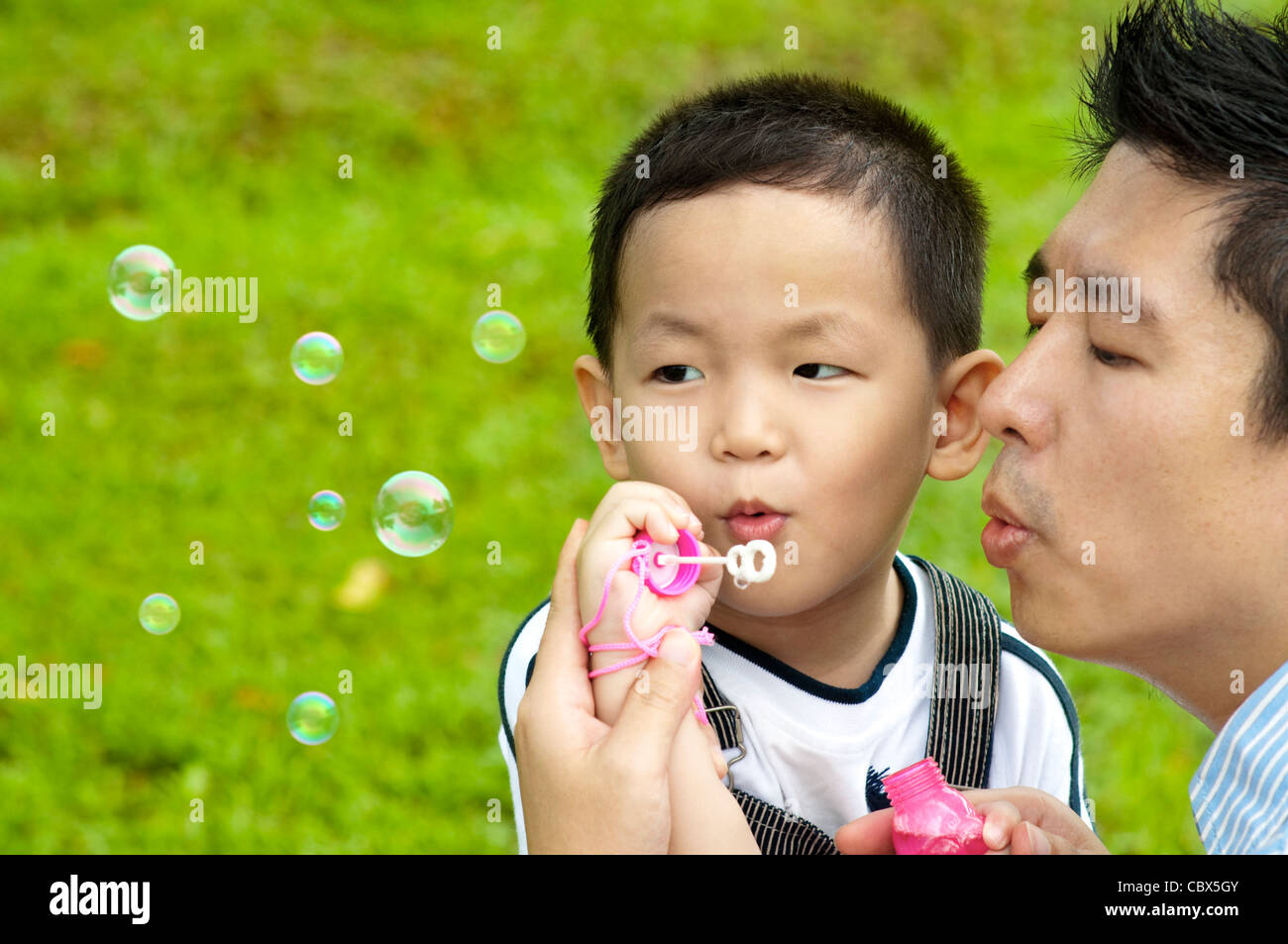 Asian father and son blowing bubbles outdoor Stock Photo Alamy
