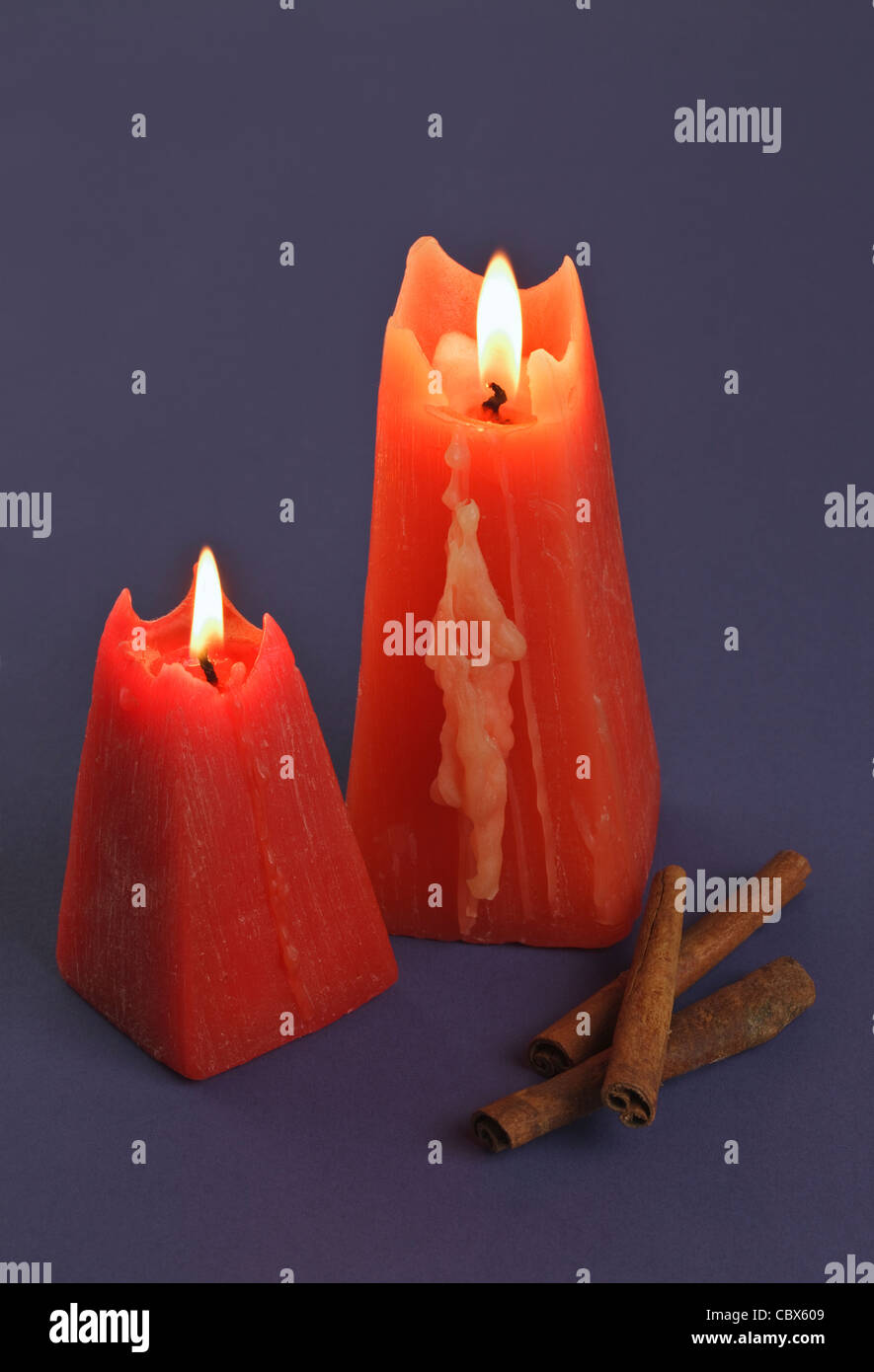 Two burning red Candles with Cinnamon sticks Stock Photo Alamy