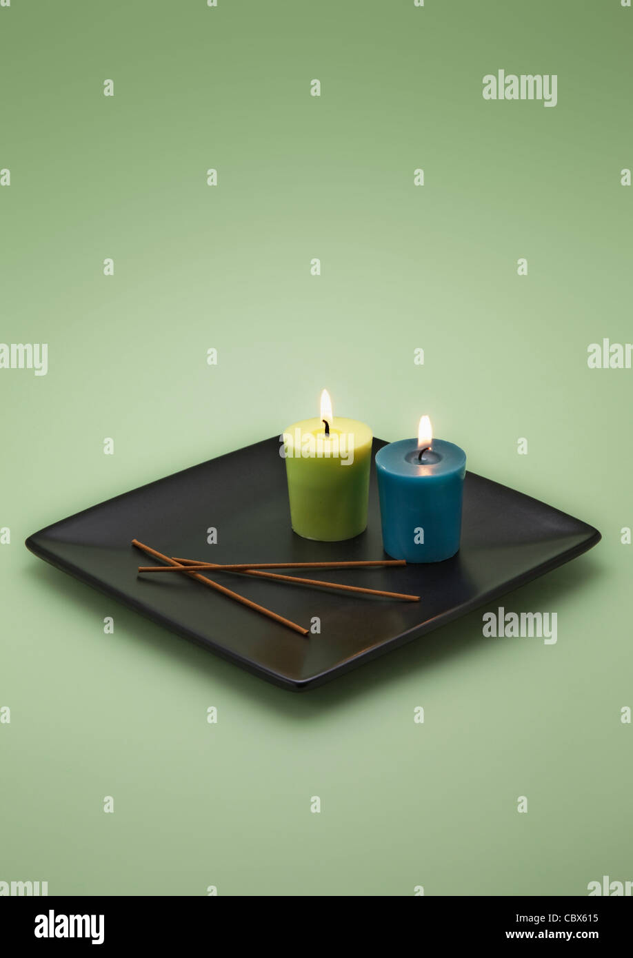 Two burning Candles on black Plate Stock Photo Alamy