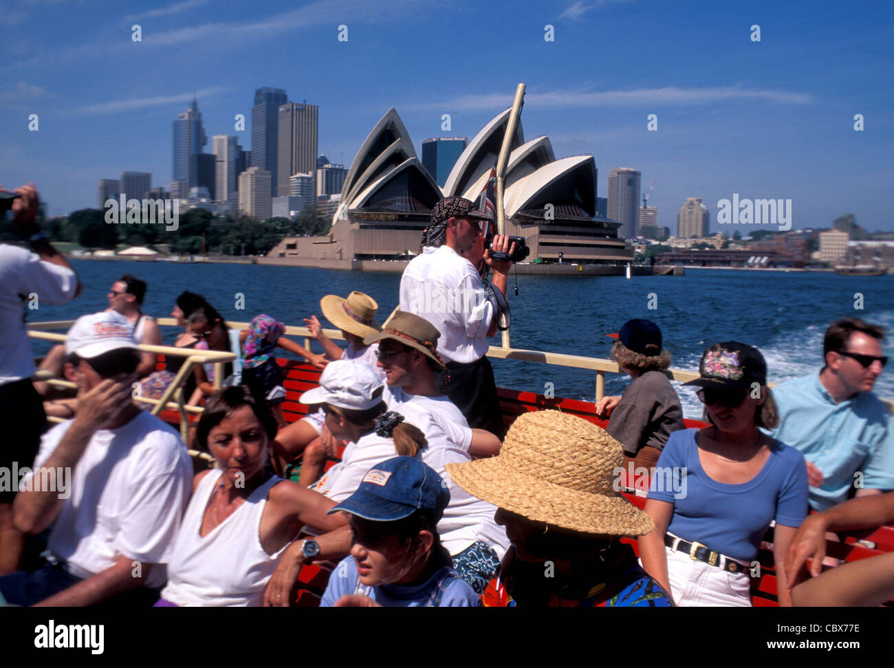 Tourists on a Sydney ferry with the Opera House in the background, NSW Australia Stock Photo