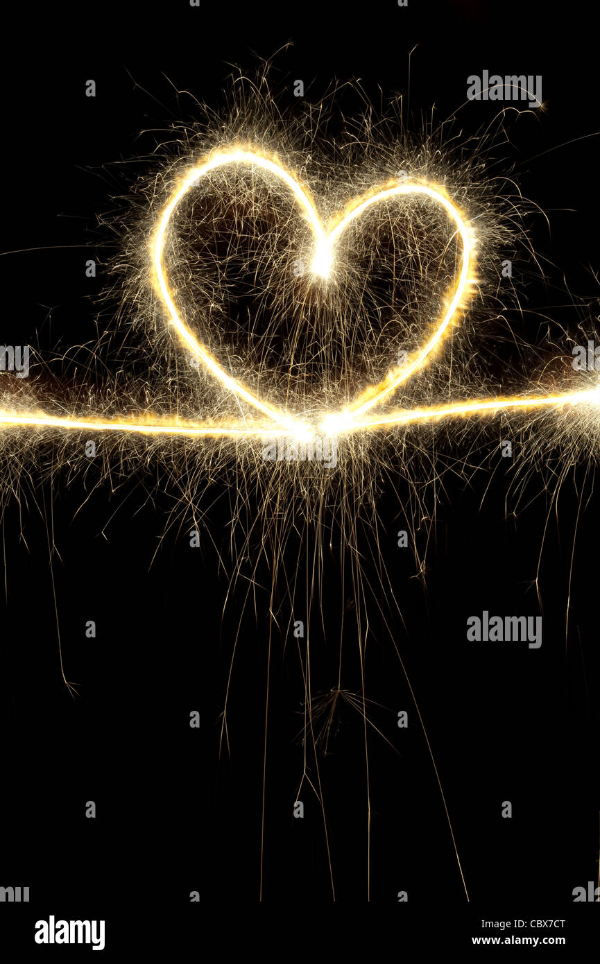 Heart shape made with sparkler at night. Stock Photo