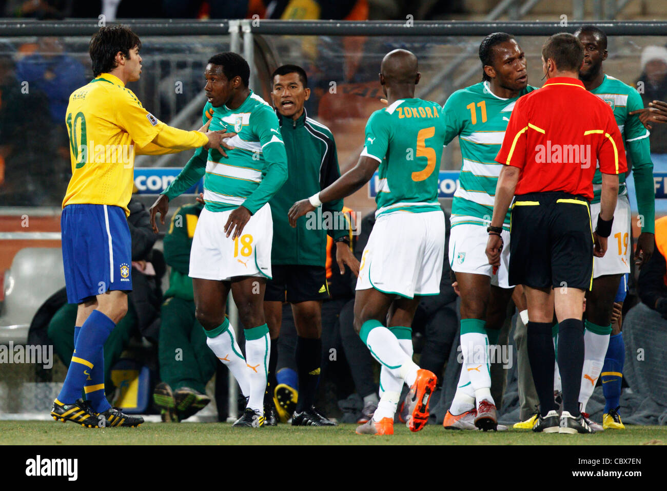 Kaka of Brazil (10) pushes Kader Keita of Ivory Coast (18) as Didier Drogba argues with referee Stephane Lannoy - '10 World Cup. Stock Photo