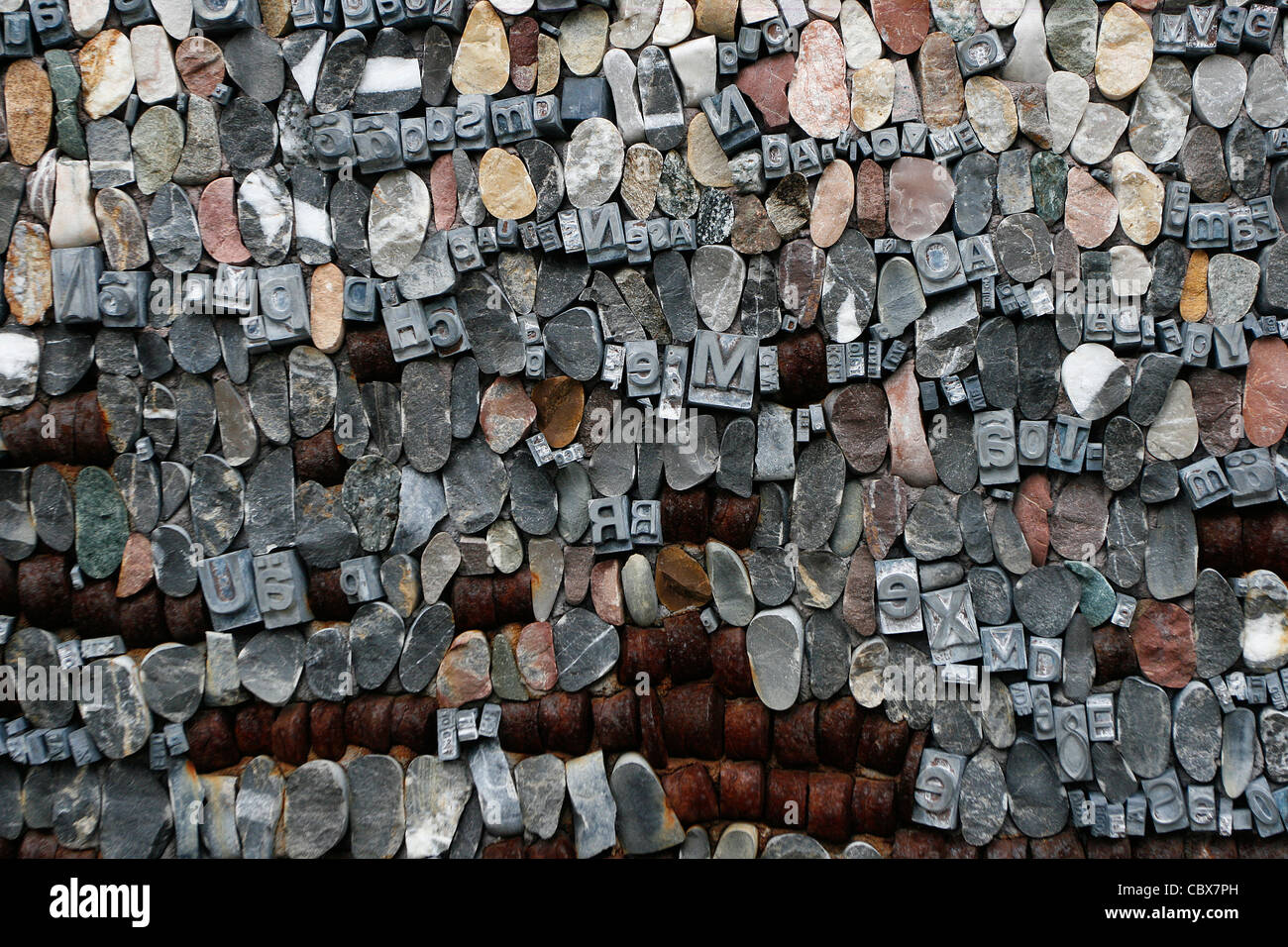 Detail of a contemporary mosaic with different materials (block letters, stones, iron). Stock Photo