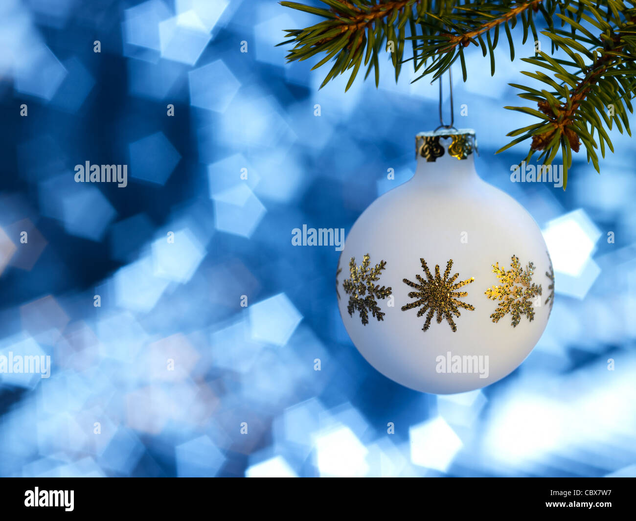Christmas bauble hanging on fir branch in blue blurry back Stock Photo
