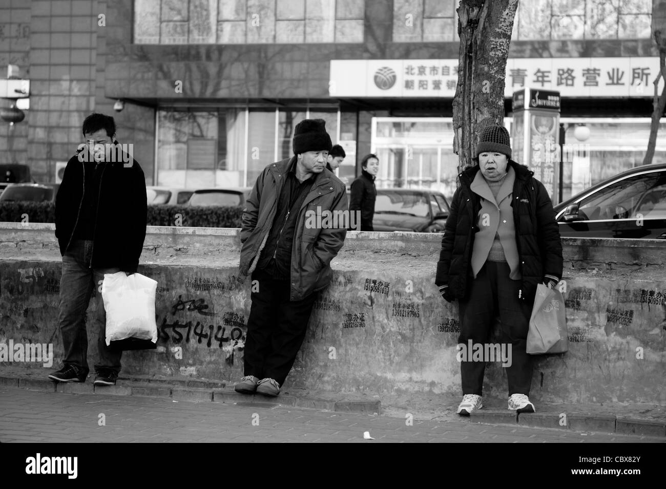 Chaoyang Road, Beijing. People waiting at a bus stop. Stock Photo
