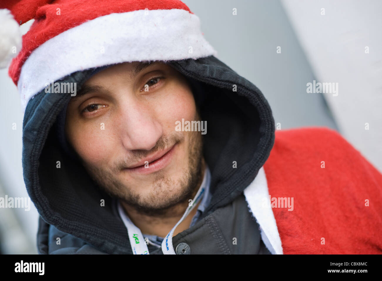Big Issue seller in Father Christmas Xmas outfit in town centre of Hay-on-Wye Powys Wales UK Stock Photo
