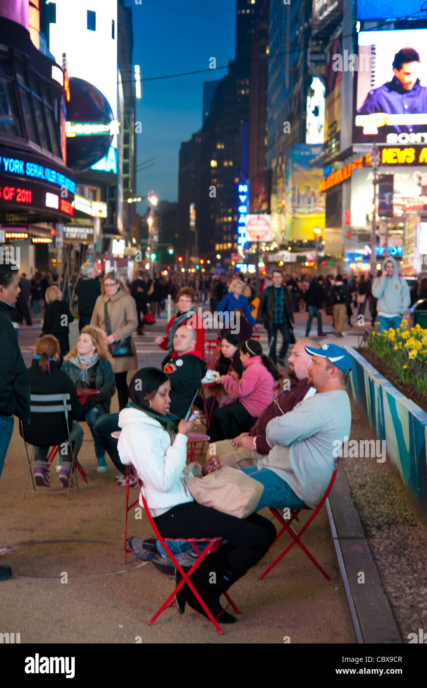 People sitting in chairs in street café on Times Square, New York City, USA Stock Photo