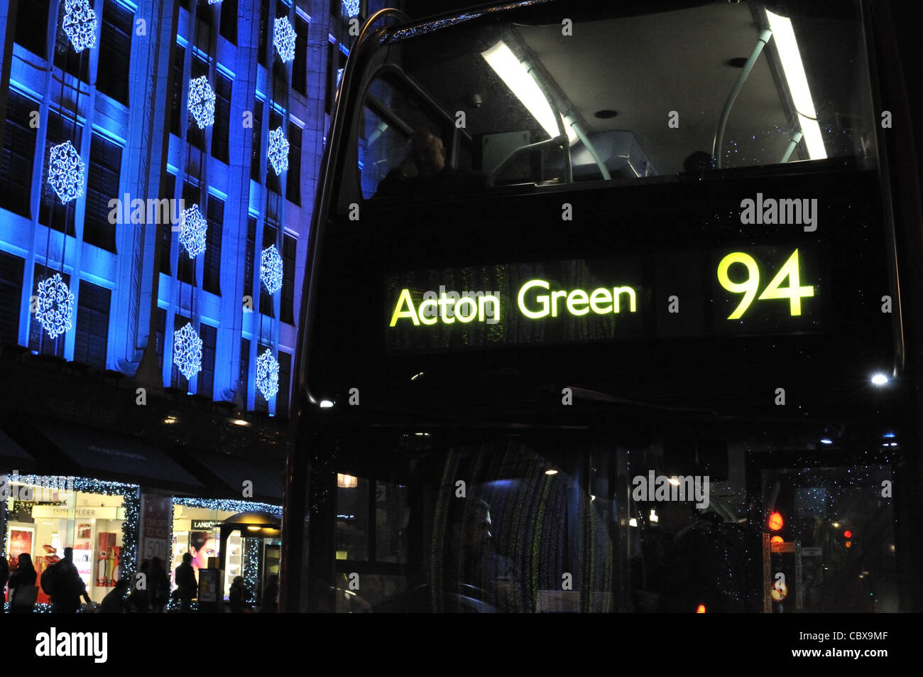 Number 94 bus for Acton Green by House of Fraser department store on Oxford Street lit up by Christmas lights, London, UK. Stock Photo