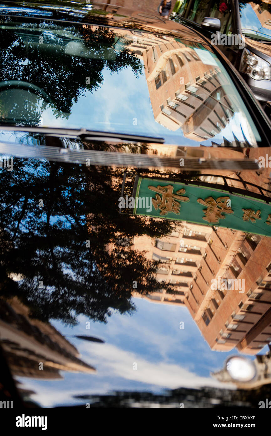 Hong Kong, Kowloon. Reflections of buildings, blue sky and trees on a car. Stock Photo