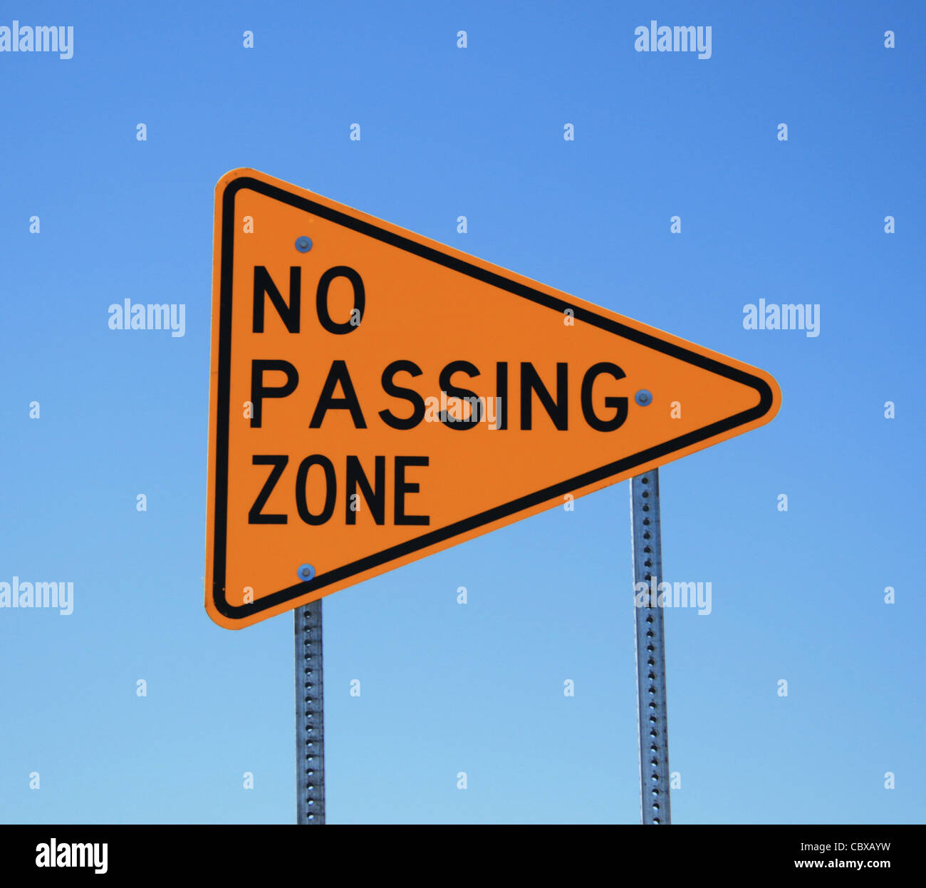 no passing zone road sign in yellow and black on blue sky background
