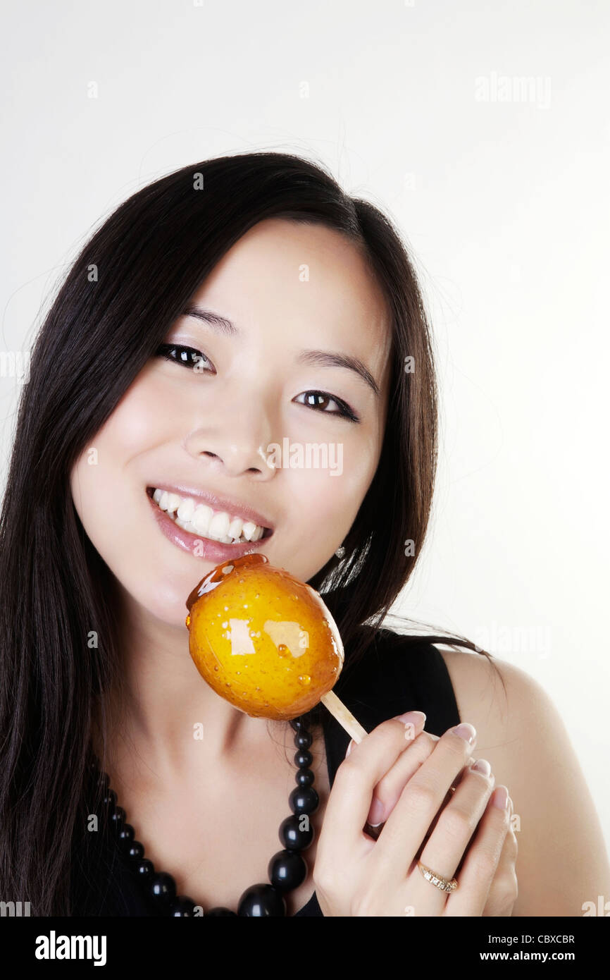 woman looking happy holding a toffee apple she about to eat Stock Photo ...
