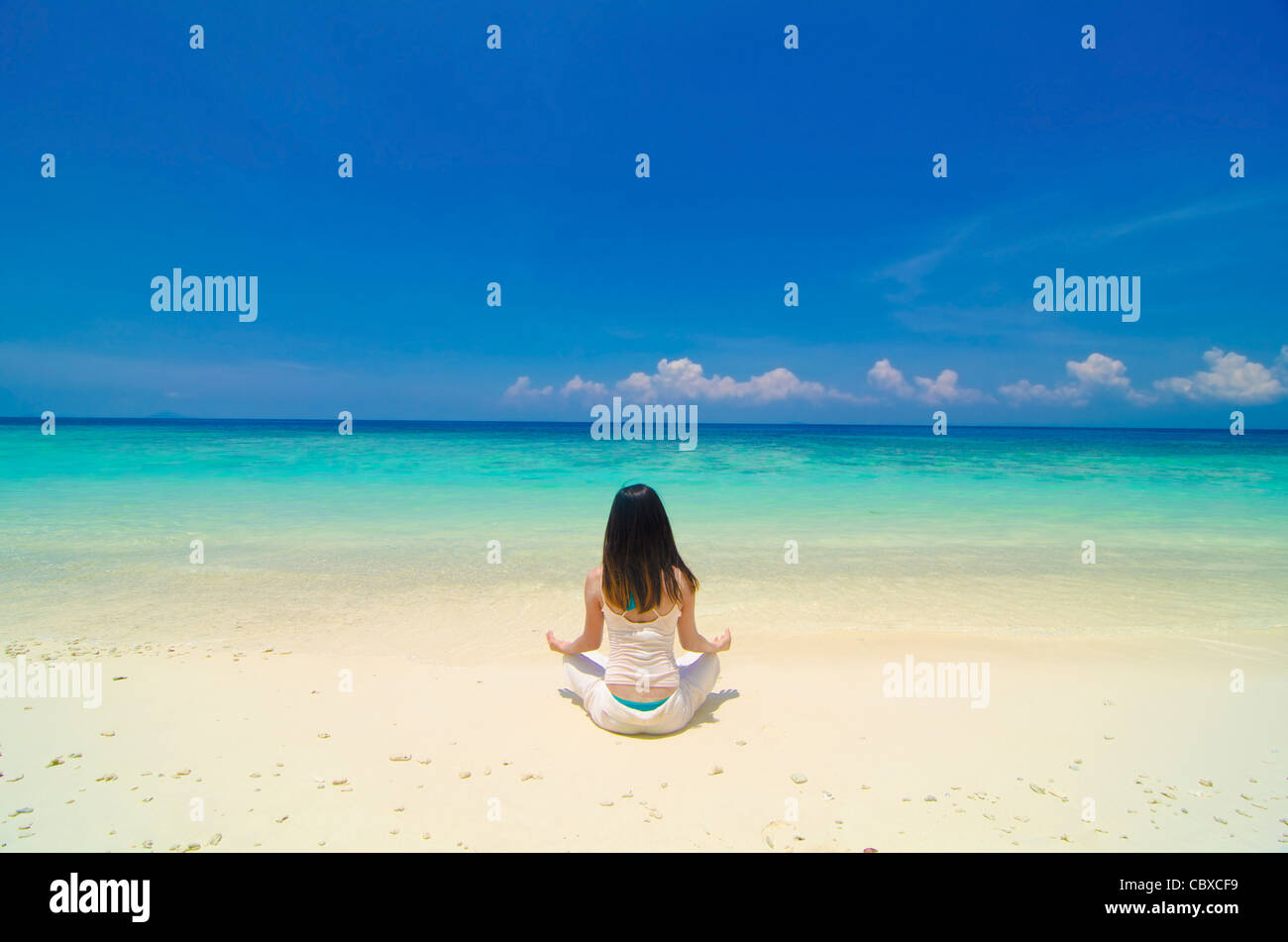 asian girl performing yoga on a beautiful beach Stock Photo