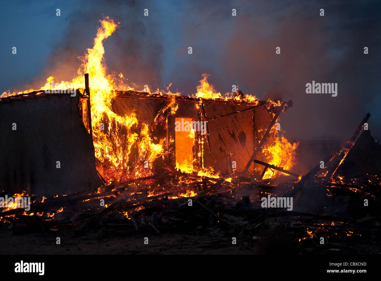 Burning old abandoned house at dusk Stock Photo