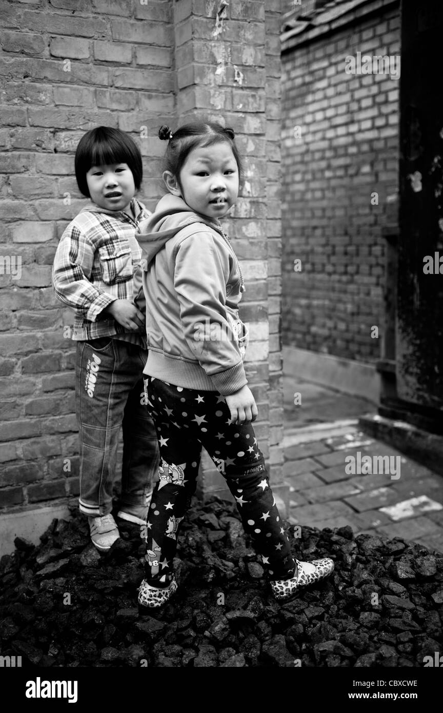 Pingyao, China. Girls playing on a pile of coal. Stock Photo