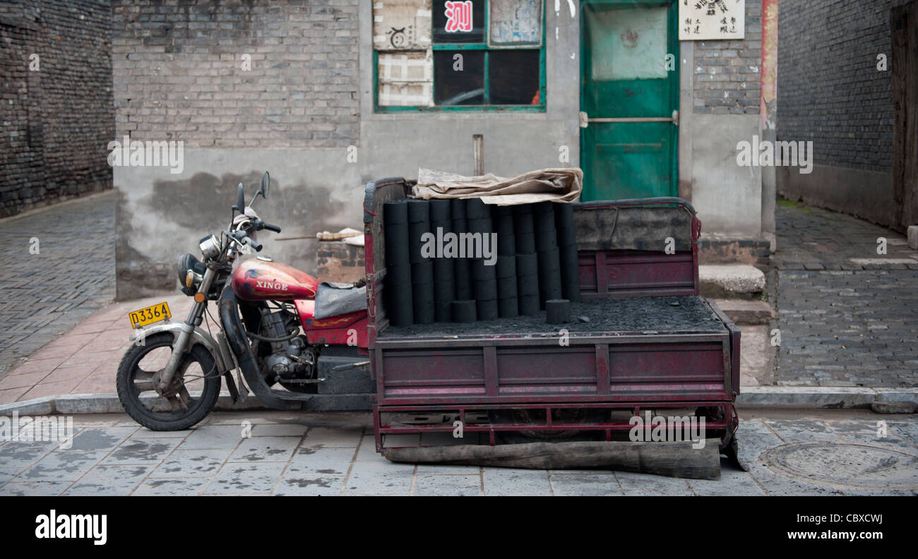 Pingyao, China. Vehicle for the delivery of coal briquettes parked on the street. Stock Photo