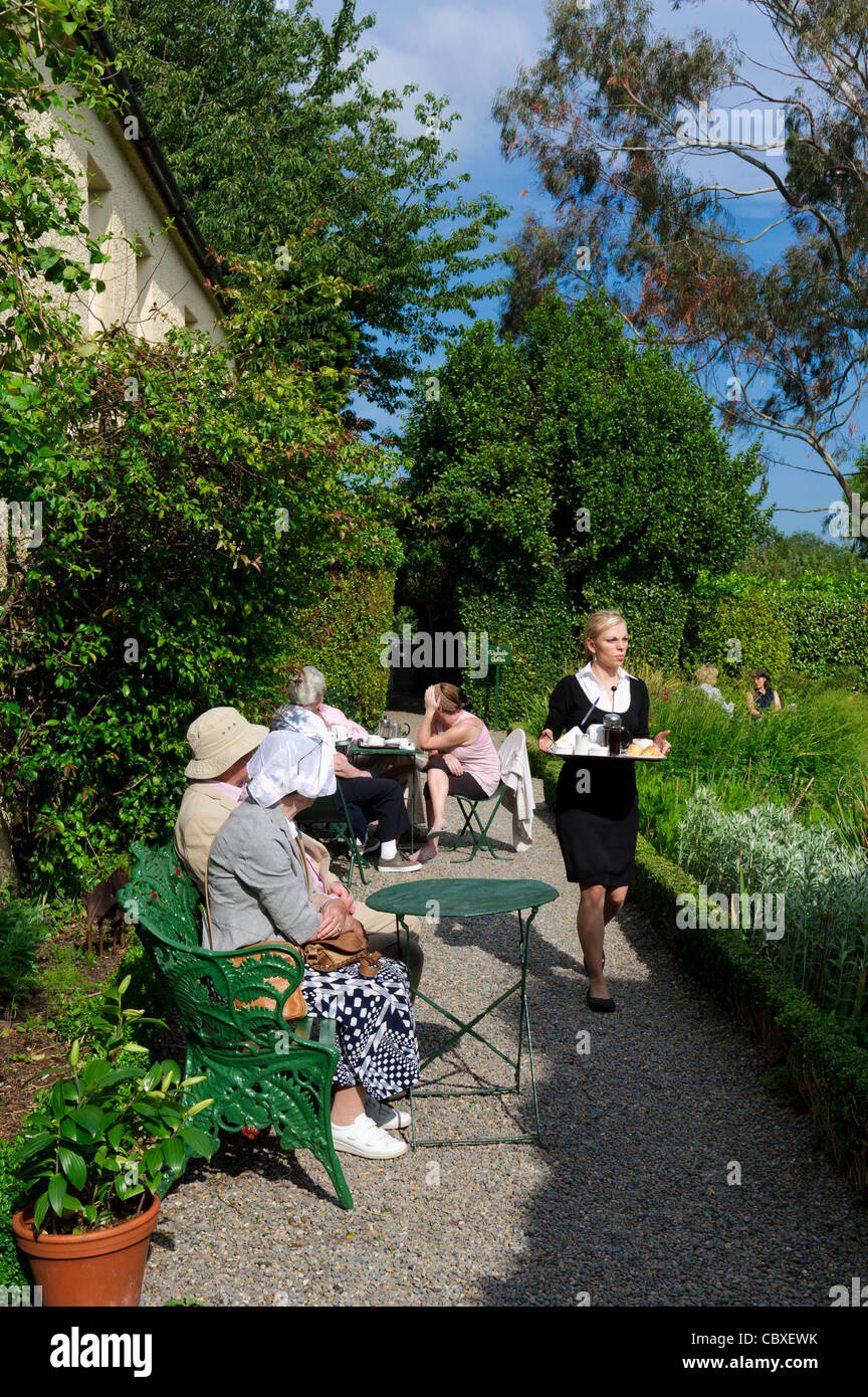 A waitress serves afternoon tea in the garden at Hunters Hotel, Rathnew