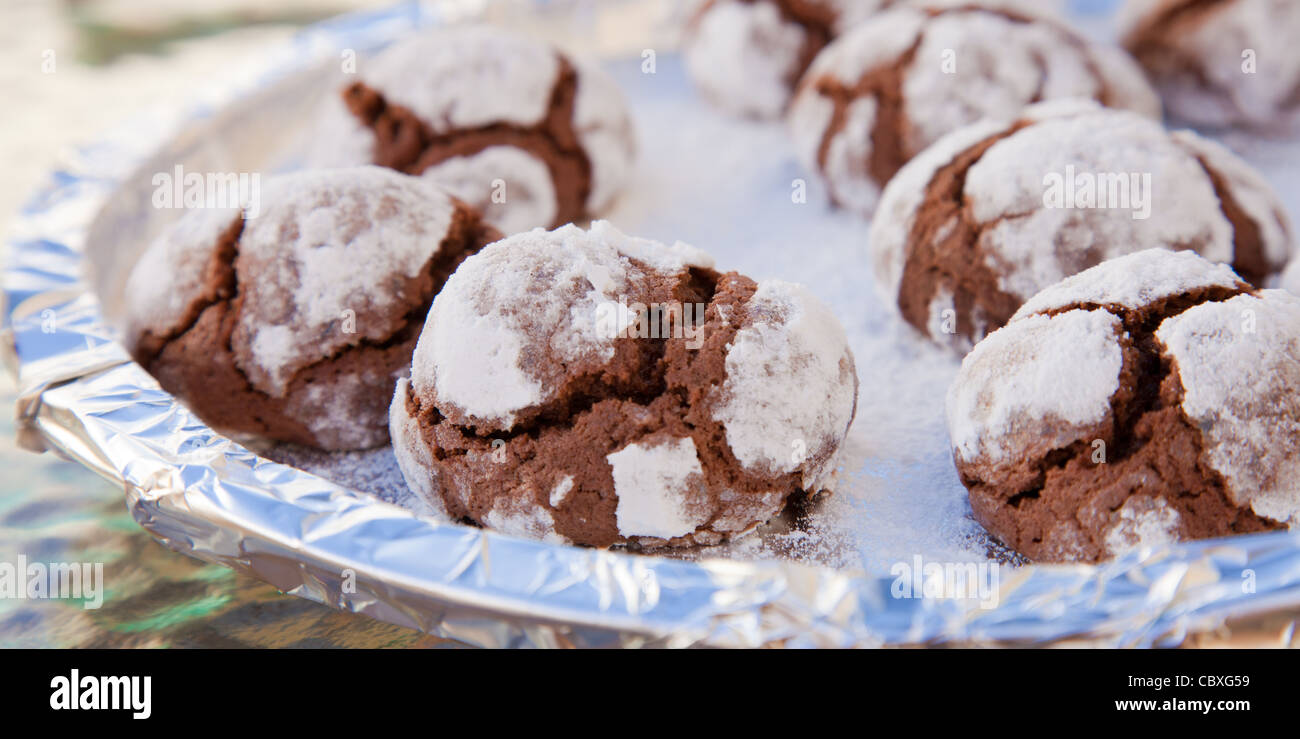 festive baking - chocolate cookies with icing sugar coating ona baking tray Stock Photo