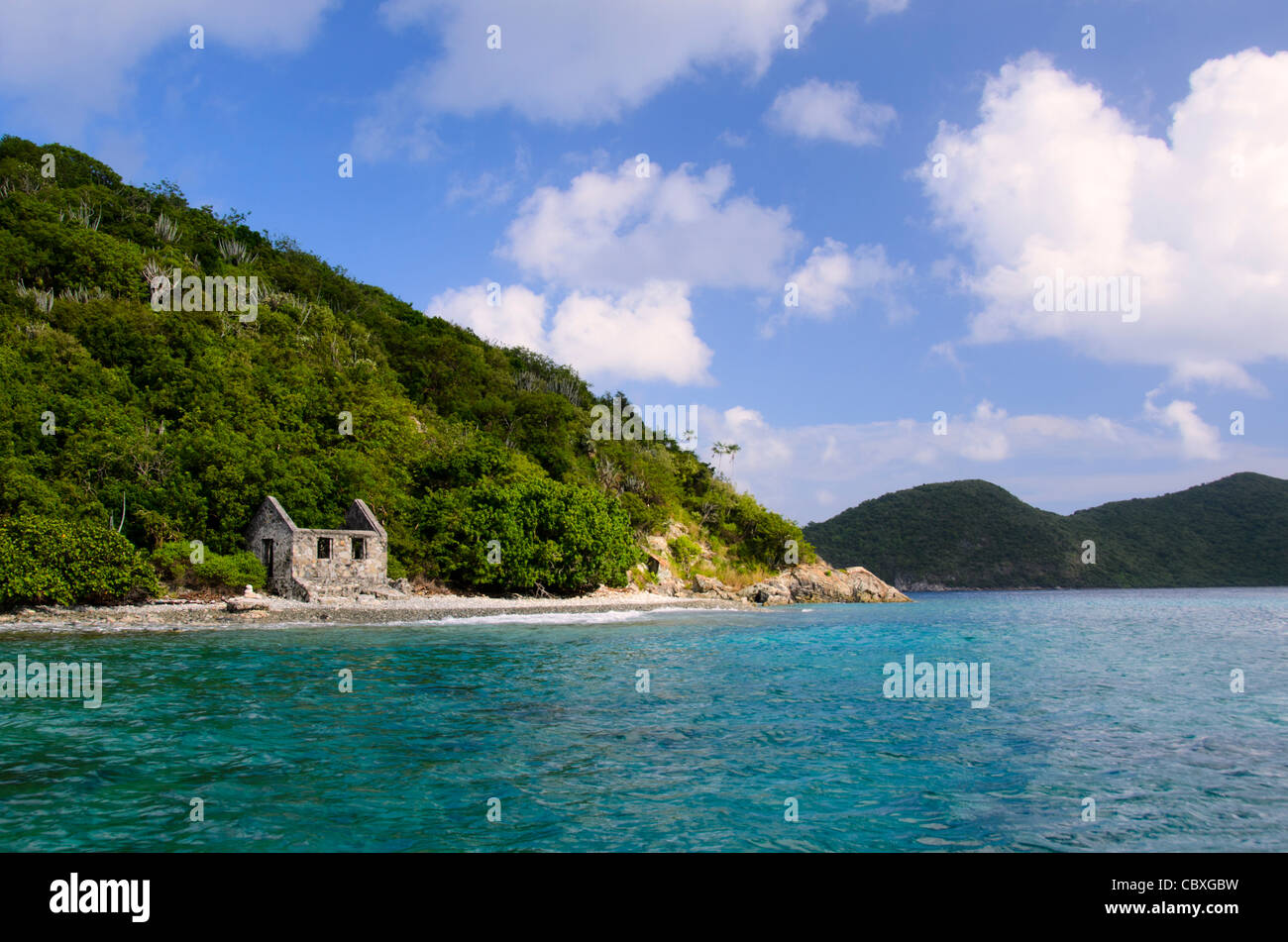 US VIRGIN ISLANDS, United States — An abandoned stone structure stands on the shore of Whistling Cay, a small, uninhabited island off the coast of St. John in the US Virgin Islands. The weathered ruins contrast with the tropical Caribbean landscape. Stock Photo