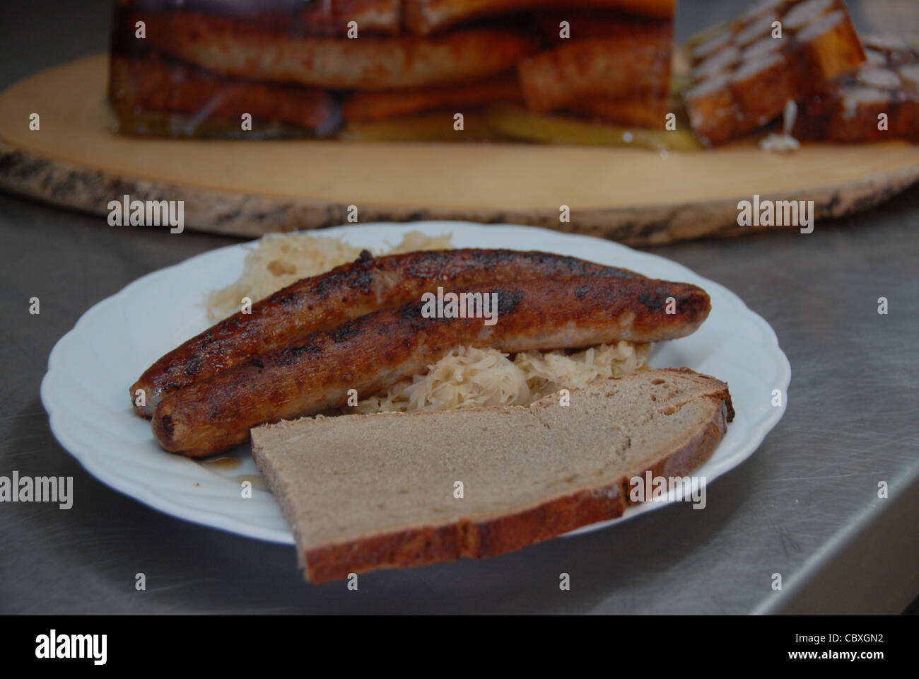 Sausage brawn (Bratwurstsülze) and Franconian grilled sausage with Sauerkraut and a slice of Bauernbrot (farmer's bread) Stock Photo