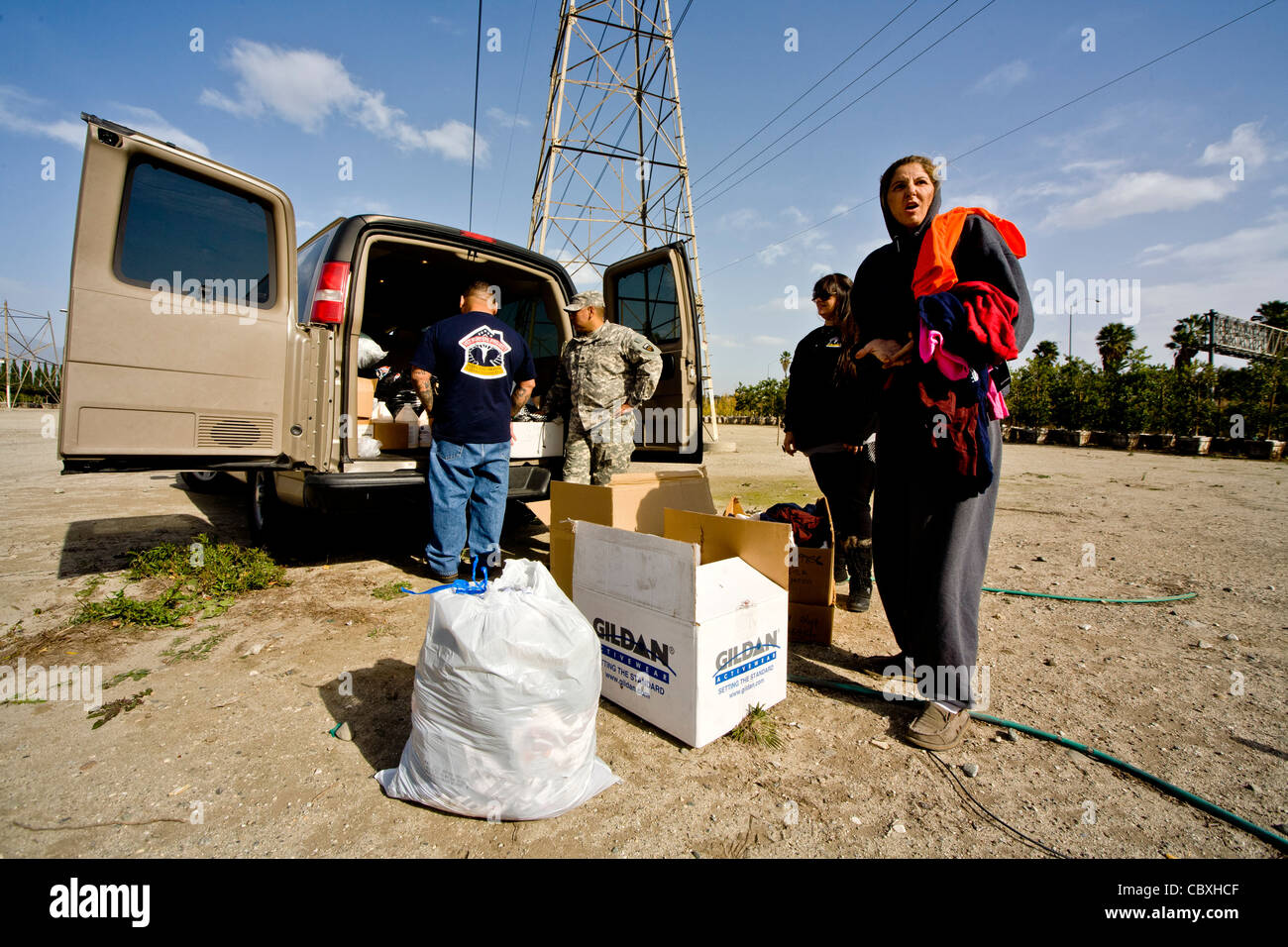 Volunteers from the charitable outreach program Vet Hunters unload food and clothing from an Army truck for homeless veterans. Stock Photo