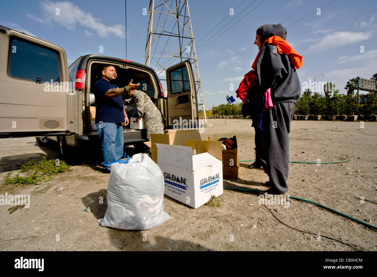 Volunteers from the charitable outreach program Vet Hunters unload food and clothing from an Army truck for homeless veterans. Stock Photo