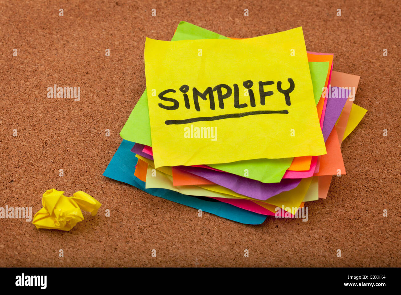pragmatic or get organized concept, simplify reminder - a stack of colorful sticky notes on cork bulletin board Stock Photo