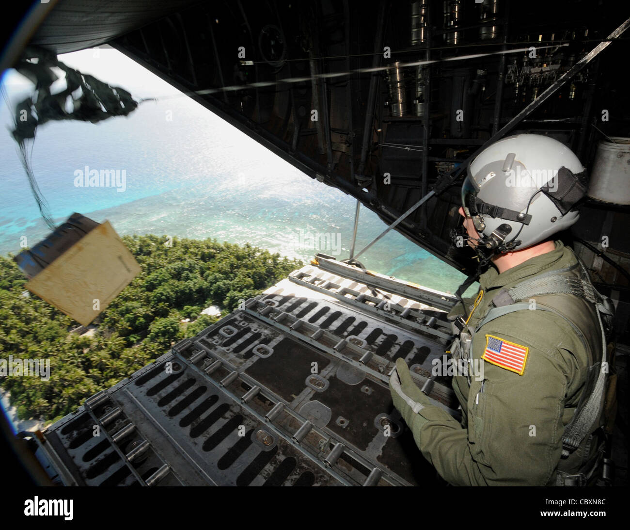 Tech. Sgt. Heath Bahyi observes boxed cargo being airdropped from a C ...