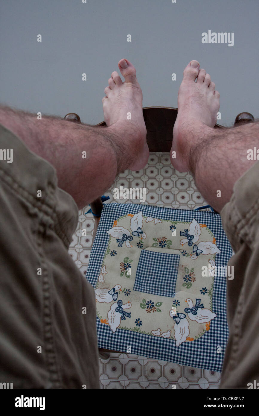 Man resting his feet on chair Stock Photo Alamy