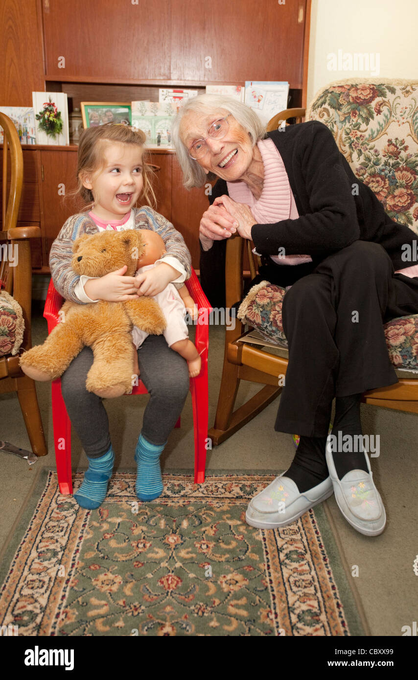 great grandmother and  great grand daughter sat together having fun Stock Photo