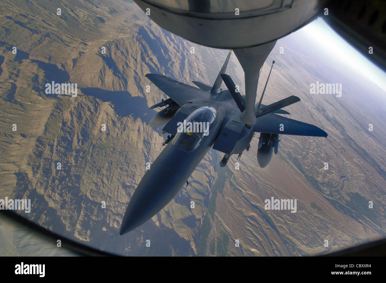 An F-15E Strike Eagle refuels over the mountains of Afghanistan April 12, 2006. The Strike Eagle is a dual-role fighter designed to perform air-to-air and air-to-ground missions. An array of avionics and electronics systems gives the F-15E the capability to fight at low altitude, day or night, and in all weather. Stock Photo