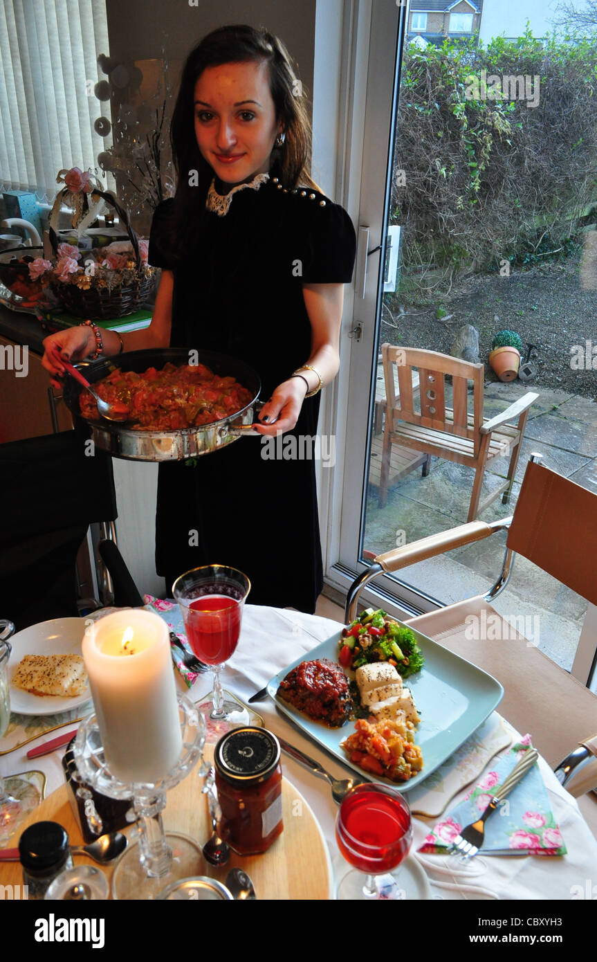 Pretty girl serving food for a special meal.  Plated food and drink at the table. Stock Photo