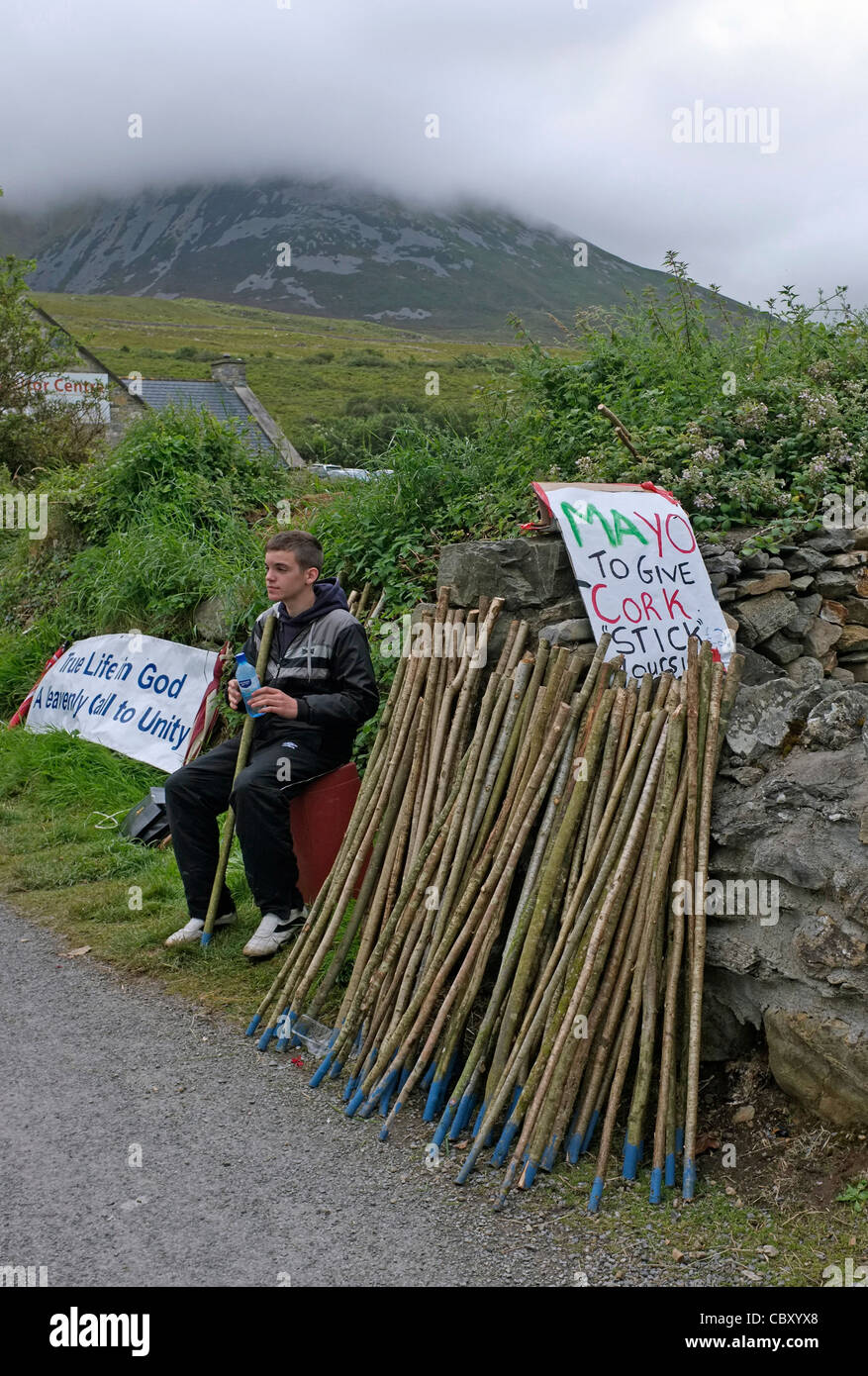 Young man selling walking sticks for the 'Reek Sunday' climb of Croagh Patrick, County Mayo, Ireland. 2011 Stock Photo