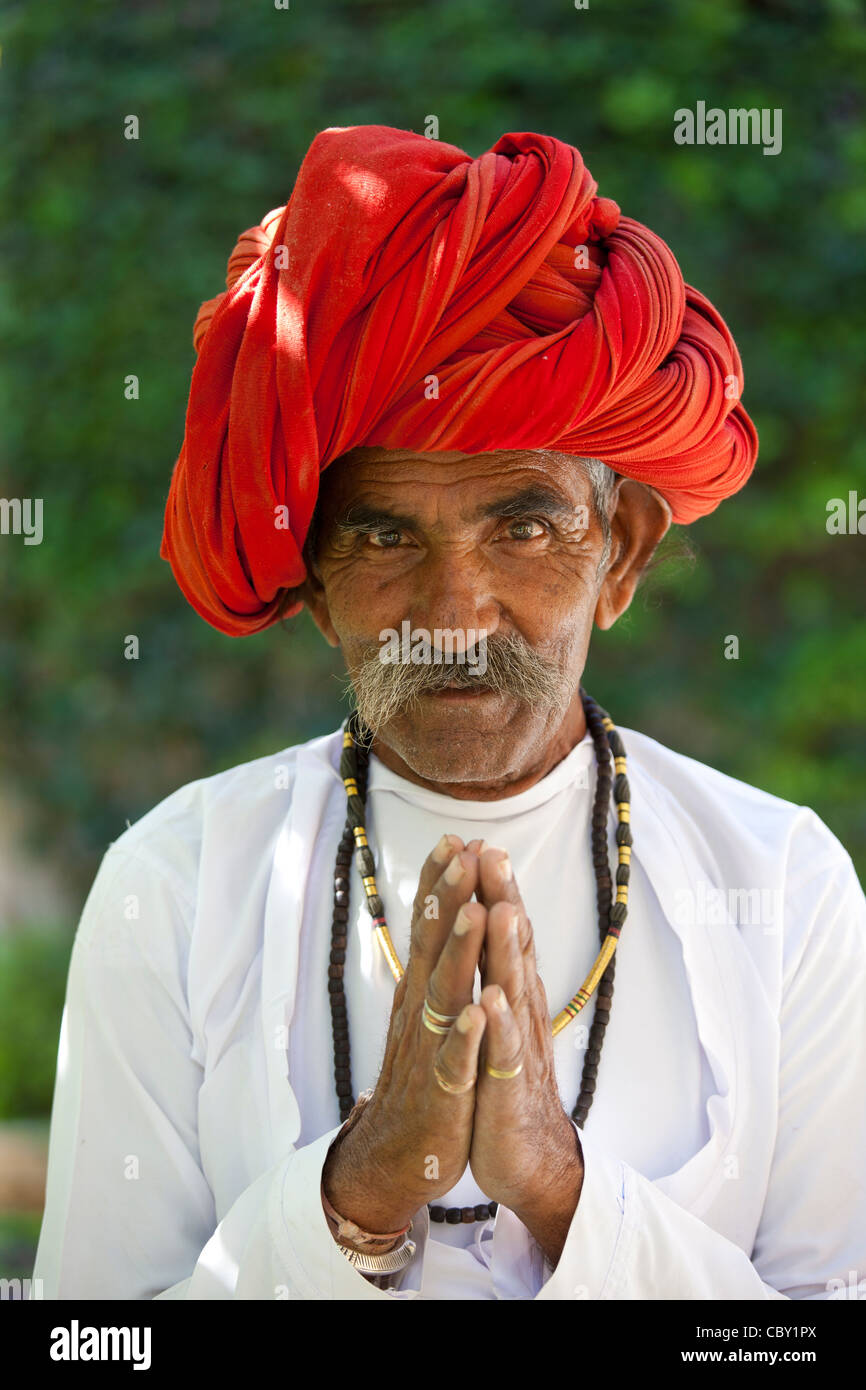 Traditional Namaste greeting from Indian man with traditional Rajasthani turban in village in Rajasthan, India. MODEL RELEASED Stock Photo