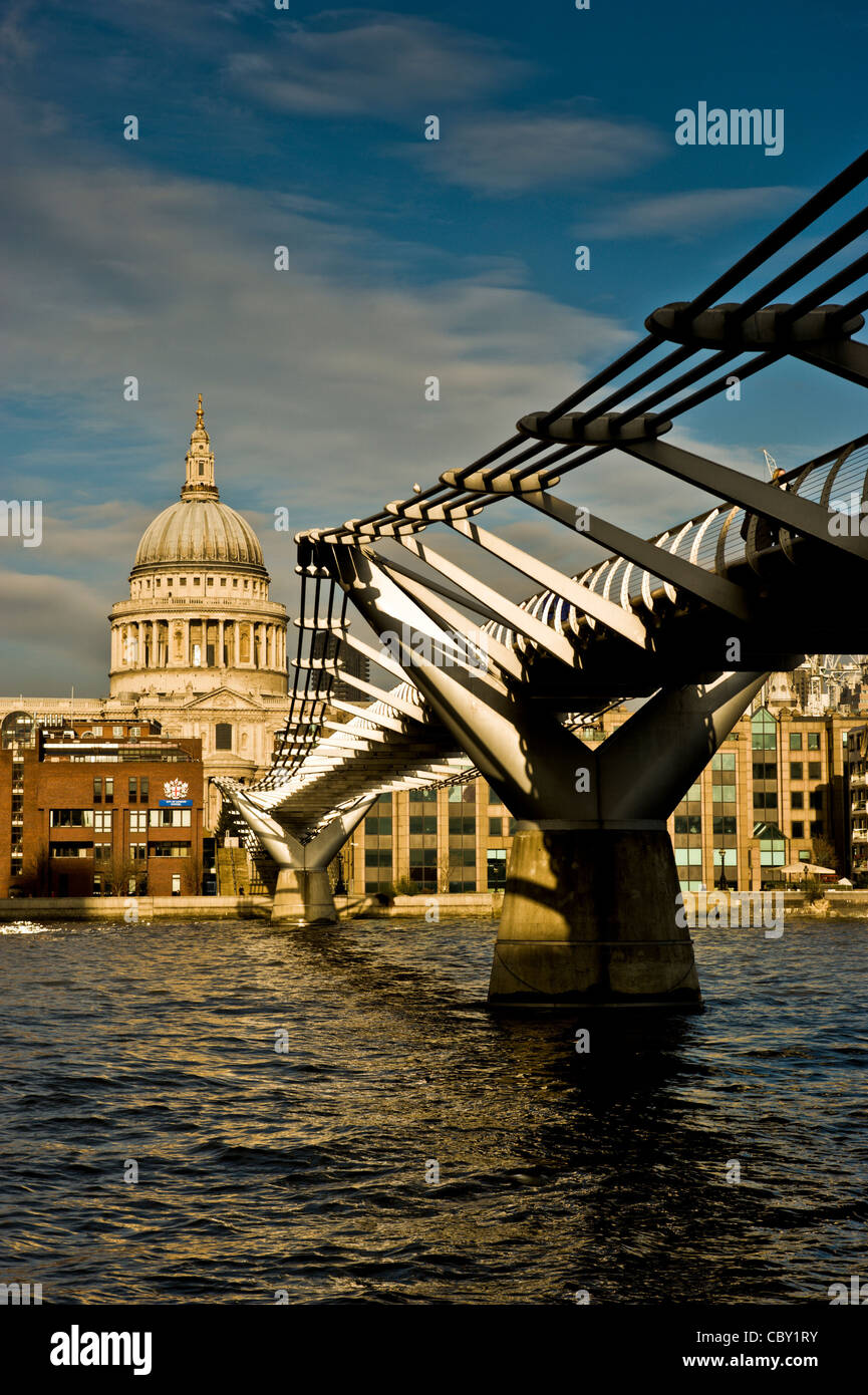 St Paul's Cathedral and the Millennium bridge over the river Thames, London. Shot from below the bridge on the south bank of the river. Stock Photo