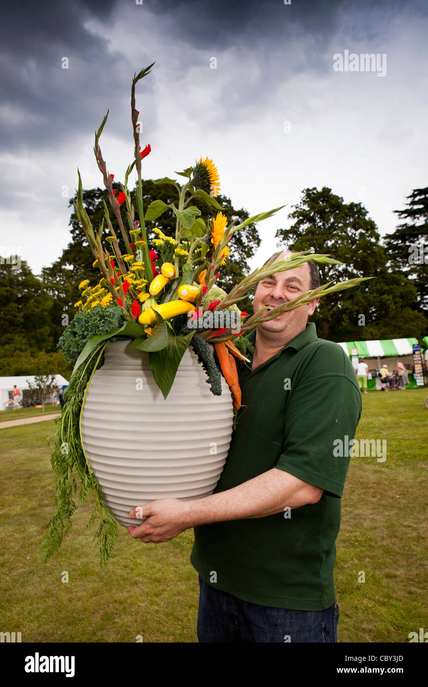UK, England, Bedfordshire, Woburn Abbey Garden Show, man carrying large flower arrangement from demonstration Stock Photo