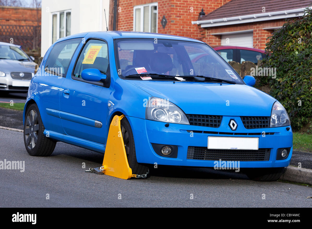 Untaxed vehicle with DVLA wheel clamp on a UK street Stock Photo