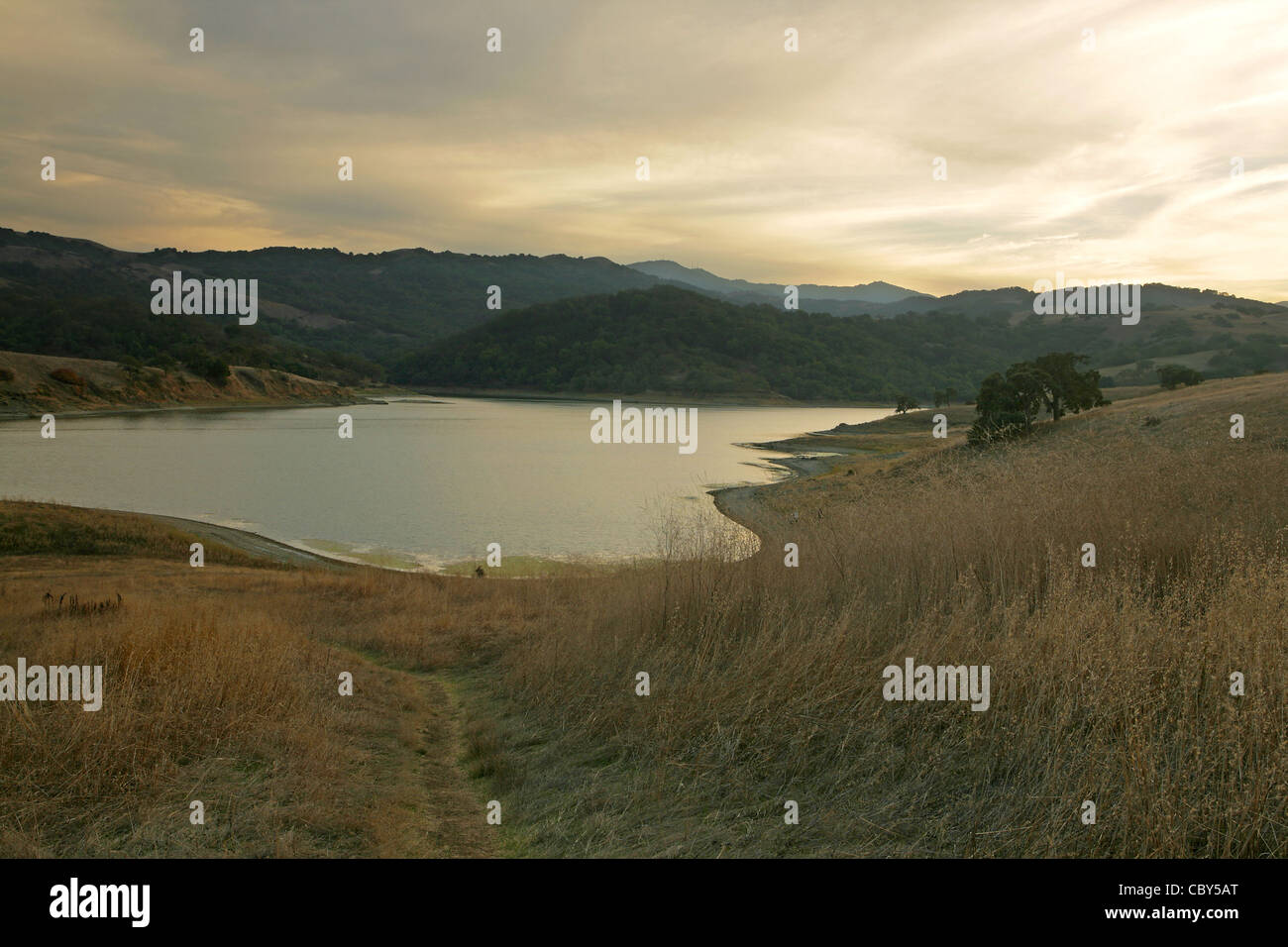 Man-made Calero Lake in the Santa Cruz Mountains of California, at dusk, with hiking path Stock Photo