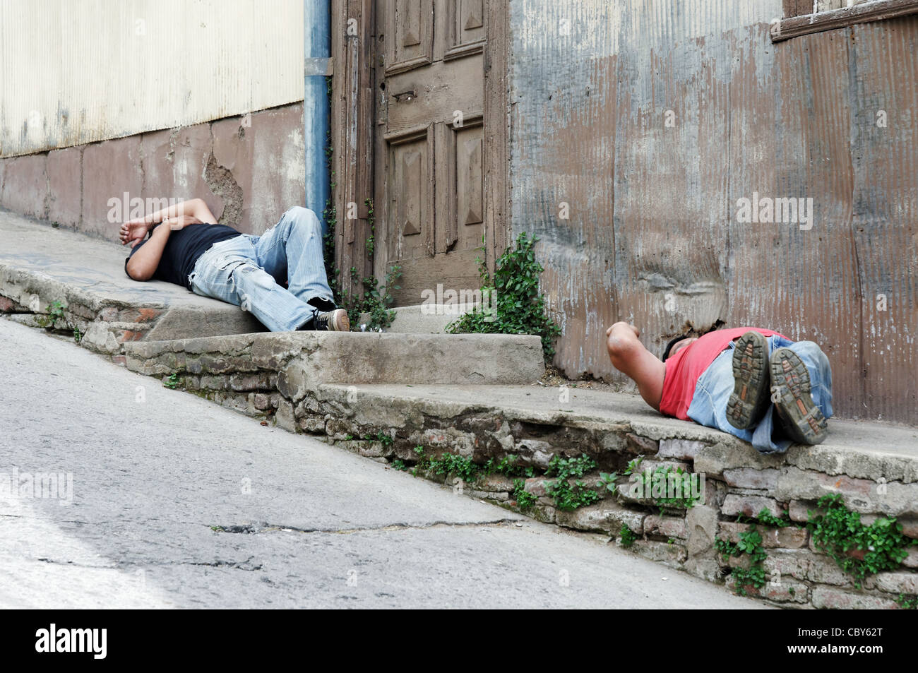 Drunk men sleeping in the street in Valparaiso, Chile Stock Photo