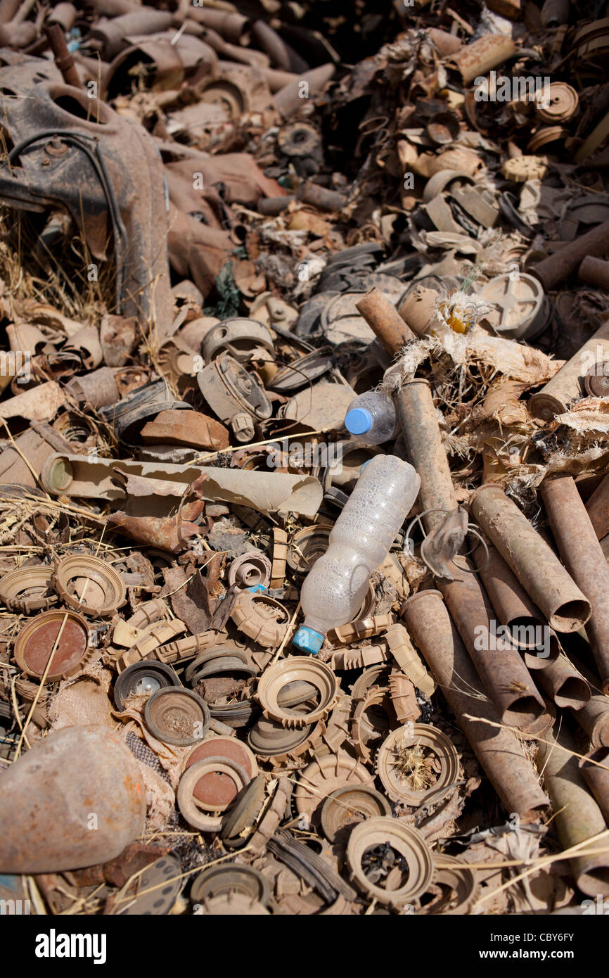 Parts of land mines and artillery and mortar shells lie rusting in the sun in a scrap yard in Iraq. Stock Photo