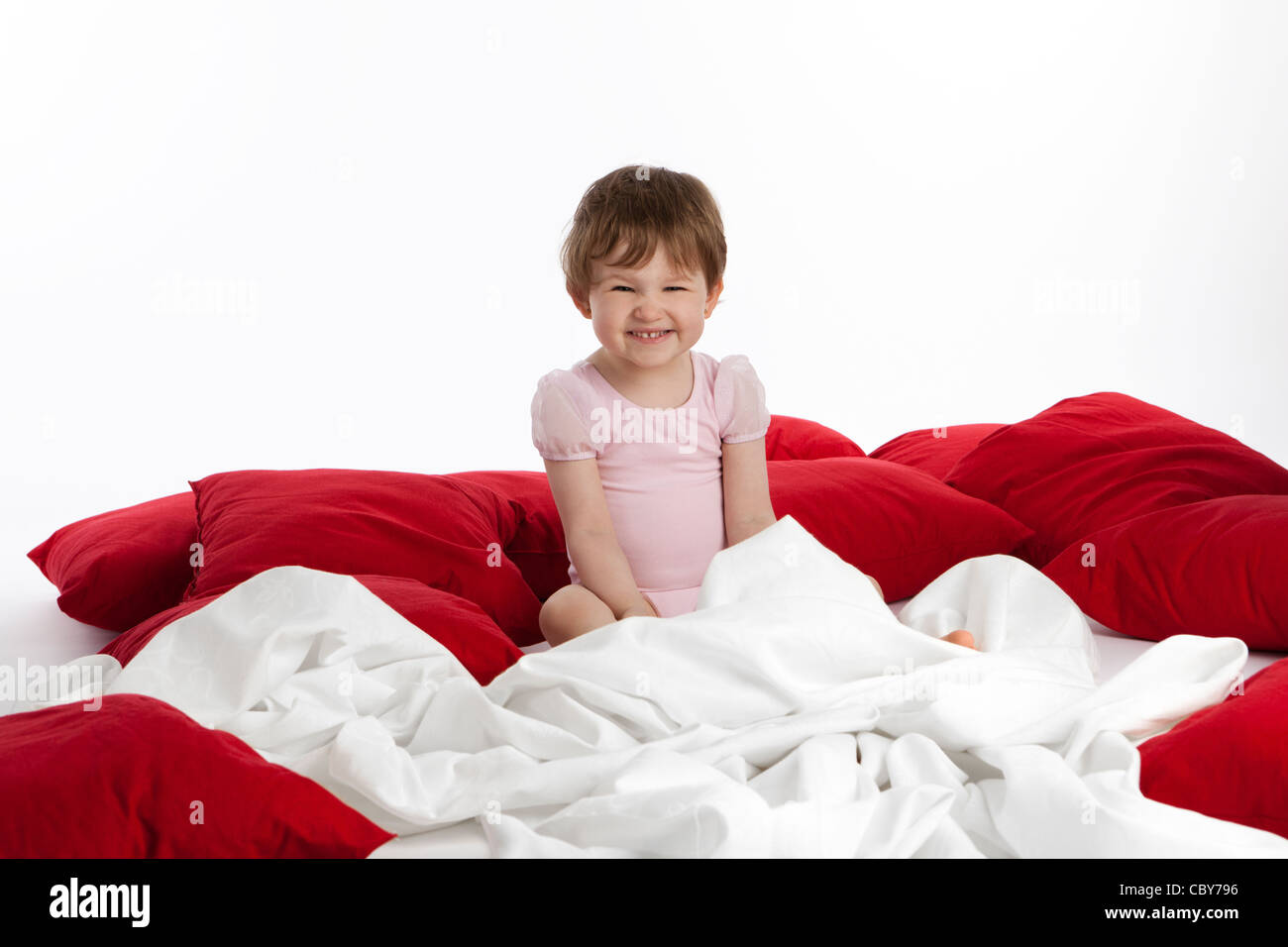 Laughing Toddler surrounded by blankets and pillows Stock Photo Alamy