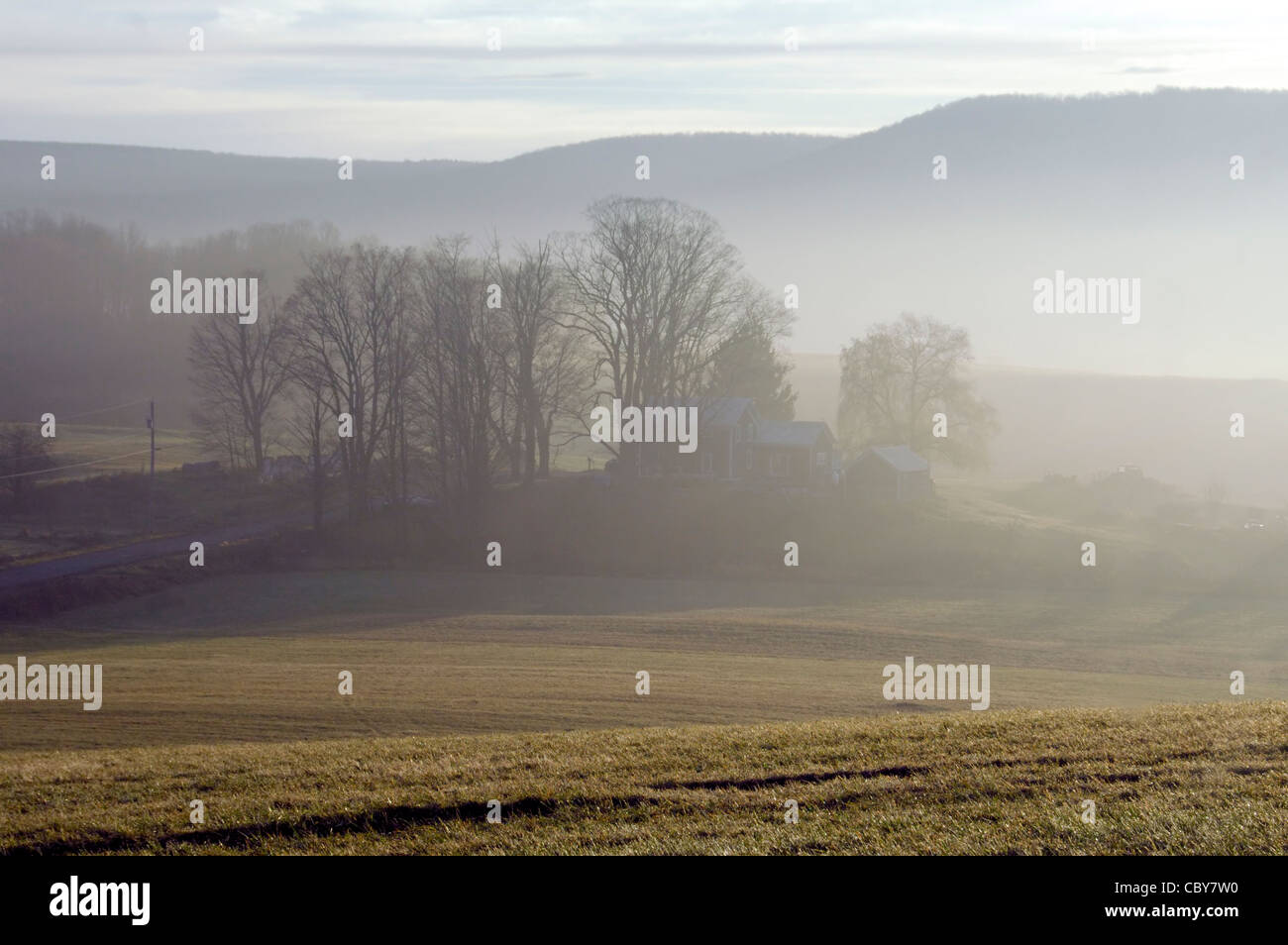 A house on a hill in fog Stock Photo