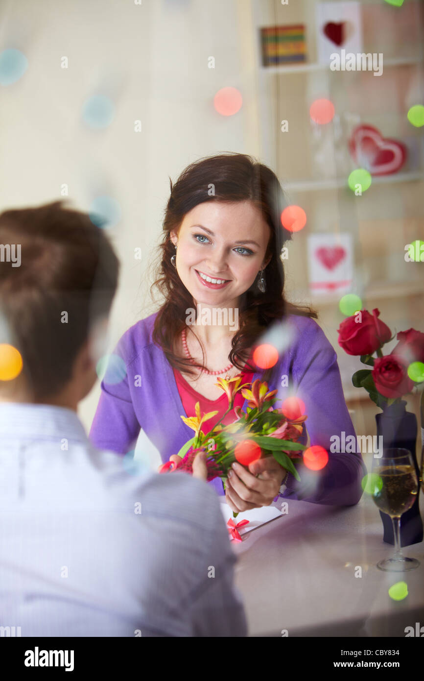 A young man giving bouquet of flowers to pretty girlfriend Stock Photo