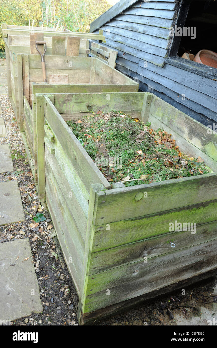 Garden compost, wooden compost bins behind garden potting shed, UK