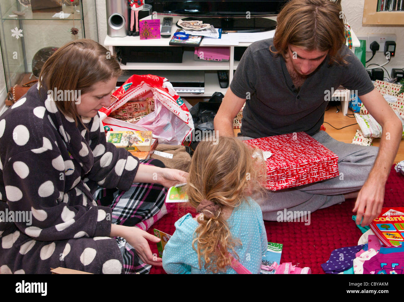 Family Opening unwrapping Xmas Christmas Presents On Christmas Day At Home Stock Photo - Alamy