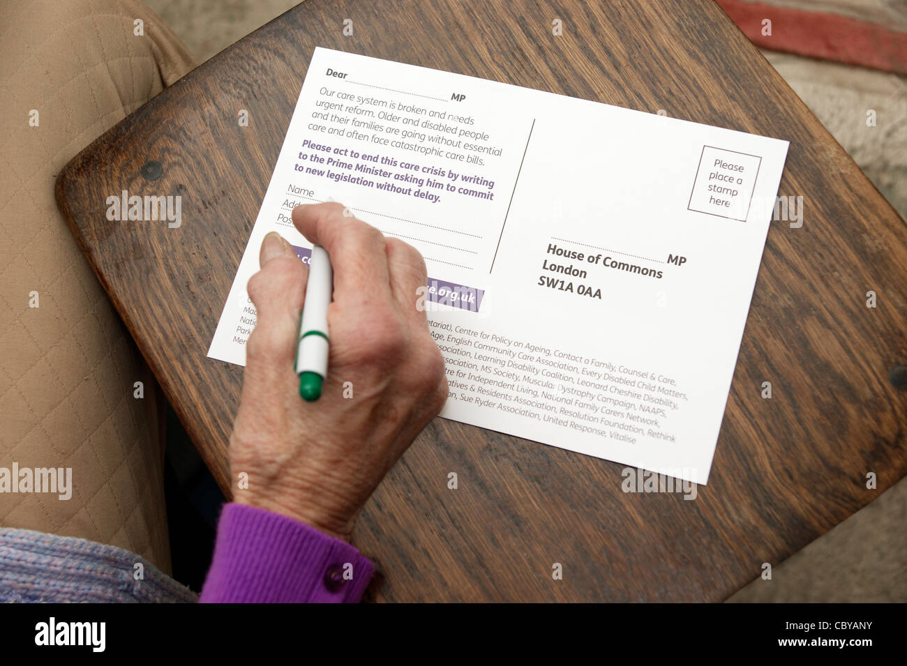 Elderly woman writing to MP to campaign for a better system & rights for older & disabled people Stock Photo